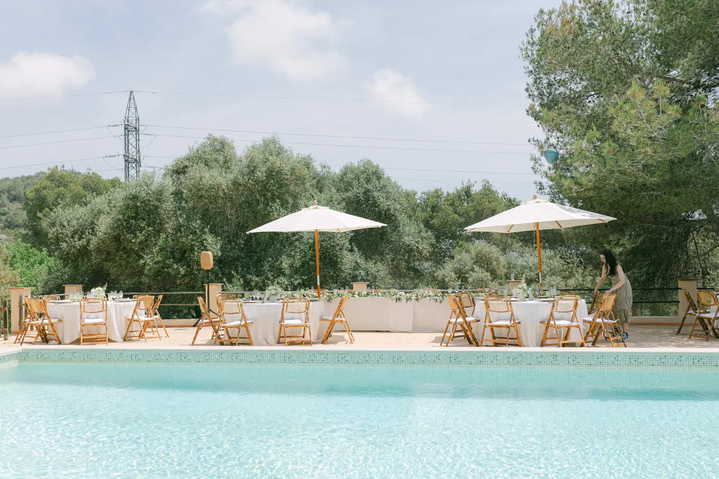 Finca de bodas junto a la piscina con sombrillas entre olivos, cerca de Barcelona