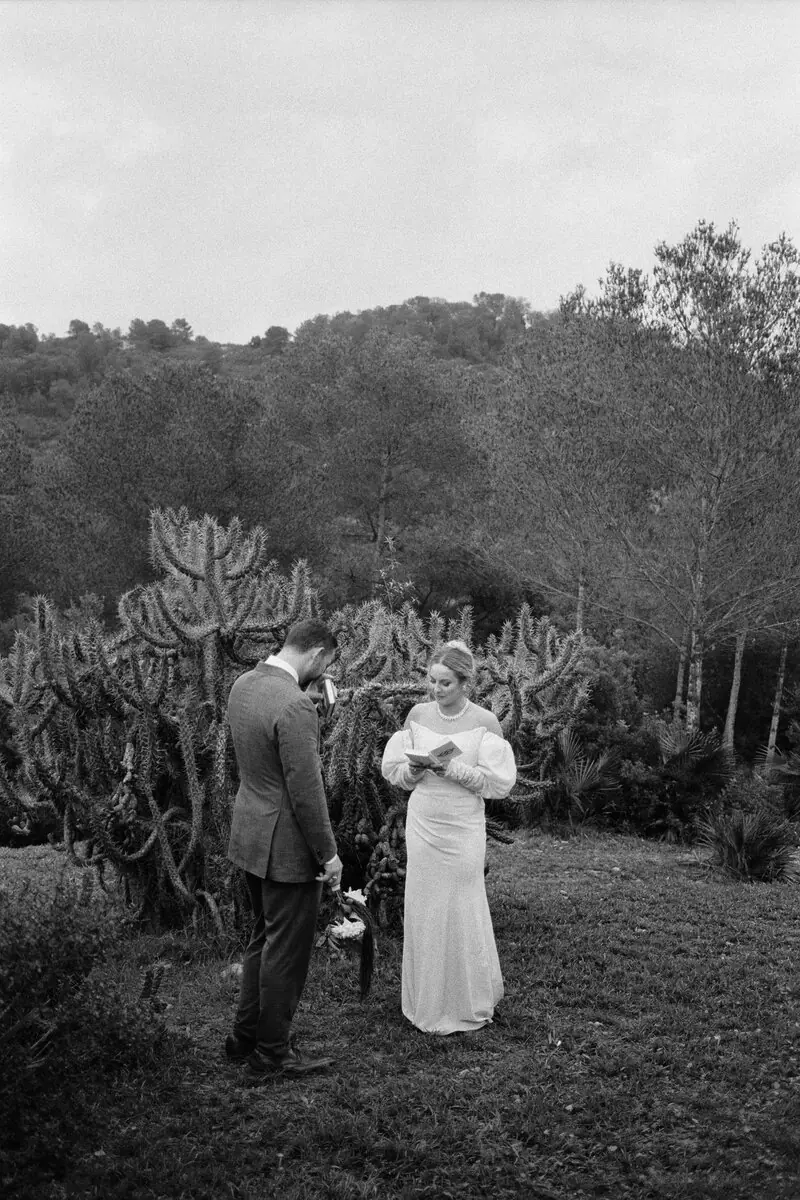 Una pareja intercambiando votos en el jardín en una ceremonia simbólica en Cataluña